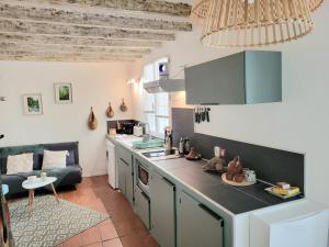a kitchen with a counter top and a living room at Le Jardin des Oiseaux in Clans
