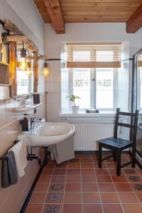 a bathroom with a sink and a tub and a chair at Ferienwohnung Dien Uttied in Grasberg +37 photos