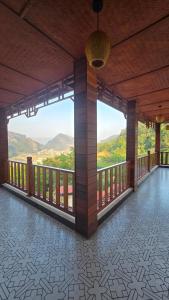 a room with a balcony with a view of the mountains at Viet Son Lam Hotel in Dồng Văn