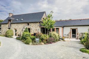 a stone house with a driveway in front of it at Ô Pré des Fleurs in Amanlis