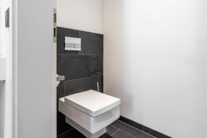 a bathroom with a white toilet and black tiles at Zollhaus - Doppelzimmer in Endingen