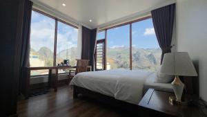 a bedroom with a bed with a view of mountains at Viet Son Lam Hotel in Dồng Văn +58 photos