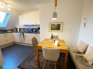 a kitchen with a wooden table and chairs at Naturpause Ferienwohnung in Schmallenberg