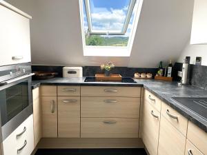 a kitchen with wooden cabinets and a window at Naturpause Ferienwohnung in Schmallenberg +15 photos