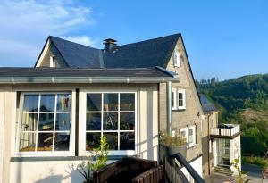 a house with large windows and a roof at Naturpause Ferienwohnung in Schmallenberg