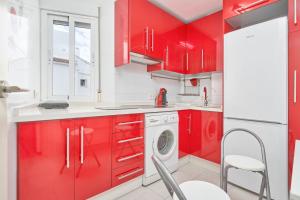 a red kitchen with red cabinets and a washing machine at Apartamento Lola 2 in Nerja