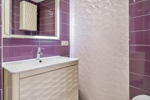 a bathroom with a sink and a mirror and purple tiles at Apartamento Lola 2 in Nerja