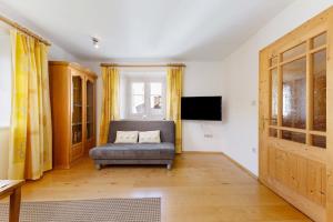 a living room with a couch and a television at Apartment Kreutnerbinderhof in Terlano