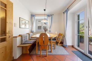 a dining room with a table and chairs at Apartment Kreutnerbinderhof in Terlano