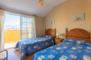 a bedroom with two beds and a large window at Beautiful duplex in Salobreña in Salobreña +18 photos