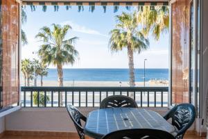 a table and chairs on a balcony with a view of the beach at Beautiful duplex in Salobreña in Salobreña