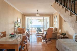 a living room with a staircase and a dining room with the ocean at Beautiful duplex in Salobreña in Salobreña