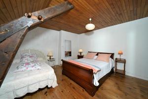 a bedroom with a bed and a wooden ceiling at La maison Bayle in Mauvezin