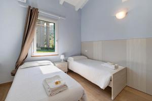 two beds in a room with a window at Ca di Perti Apt 3 in Finale Ligure