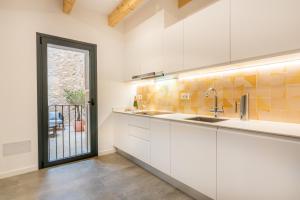 a kitchen with white cabinets and a large window at Cas Suis 9 in Campanet