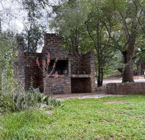 a brick fireplace in the middle of a park at Venterspoort Farmhouse in Philipstown