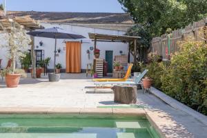 a backyard with a swimming pool and an umbrella at Casa Encarnacion in Granada