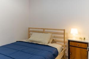 a bedroom with a blue bed and a night stand at Pollicita 80 in Chiaramonte Gulfi