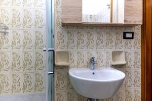 a bathroom with a sink and a glass shower at Pollicita 80 in Chiaramonte Gulfi +15 photos