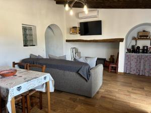 a living room with a bed and a table with a tableablish at Casa do Aguadeiro in São Marcos do Campo