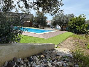a swimming pool in a yard with grass and trees at Casa do Aguadeiro in São Marcos do Campo