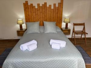 a large bed with two white towels on it at Casa do Aguadeiro in São Marcos do Campo +22 photos