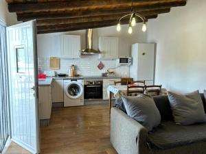 a living room with a couch and a kitchen at Casa do Aguadeiro in São Marcos do Campo