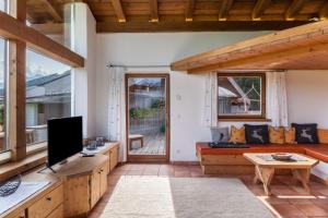 a living room with a couch and a tv at Panorama Lodge Leutasch mit Sauna in Leutasch