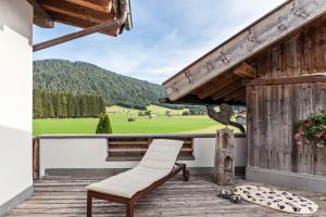 a chair on a porch with a view of a field at Panorama Lodge Leutasch mit Sauna in Leutasch
