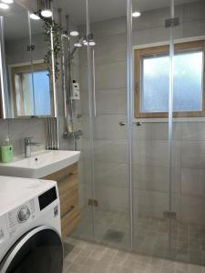 a bathroom with a shower and a washing machine at Helsinki Green Retreat in Helsinki +9 photos