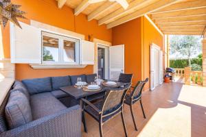 a living room with a couch and a table and chairs at Villa Amelia cerca de cala Pi in Llucmajor