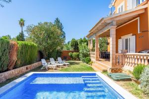 a backyard with a swimming pool and a house at Villa Amelia cerca de cala Pi in Llucmajor