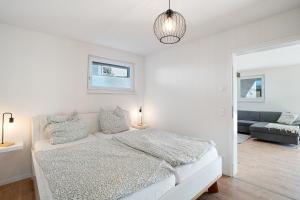 a white bedroom with a bed and a couch at Ferienwohnung am Tanzberg in Oberkirch