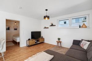 a living room with a couch and a television at Ferienwohnung am Tanzberg in Oberkirch