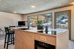 a kitchen with a sink and a counter with a window at Lena Dolomites Gartensuite in Villnoss +20 photos