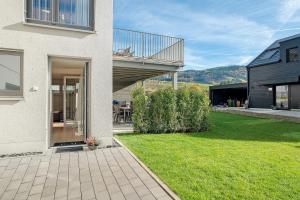 a house with a balcony and a yard with grass at Ferienwohnung am Tanzberg in Oberkirch