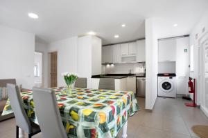 a kitchen and a dining room with a table and chairs at Casa Ribeiro Alojamento Local in São Martinho do Porto +13 photos