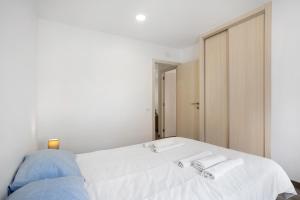 a bedroom with a white bed with two towels on it at Casa Ribeiro Alojamento Local in São Martinho do Porto