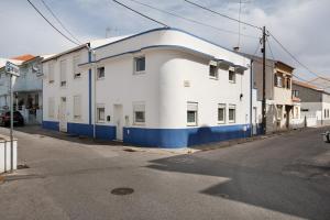 a white and blue building on the side of a street at Casa Ribeiro Alojamento Local in São Martinho do Porto