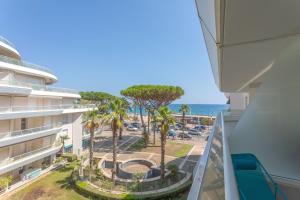 an apartment balcony with a view of a parking lot and the ocean at Superbe Appartement vue mer in Fréjus