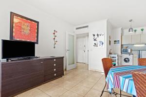 a living room with a flat screen tv on a dresser at Superbe Appartement vue mer in Fréjus