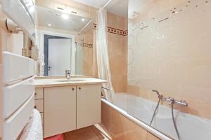 a bathroom with a sink and a tub and a shower at Superbe Appartement vue mer in Fréjus +18 photos