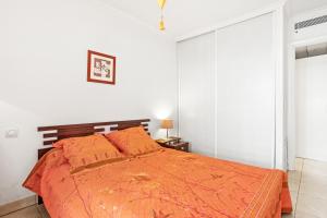 a bedroom with a bed with an orange comforter at Superbe Appartement vue mer in Fréjus