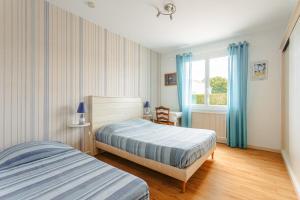 a bedroom with two beds and a window at Maison d'hôtes Le Grillon in La Brée-les-Bains
