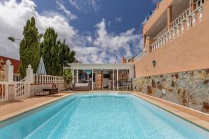 a swimming pool in front of a house at Casa Marron in Costa Calma