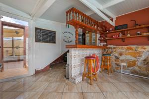 a kitchen with a stone fireplace and two stools at Casa Marron in Costa Calma
