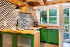 a kitchen with green cabinets and a bottle of wine at Gästehaus Wüpping 3 in Salem