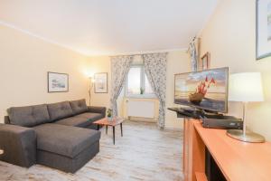 a living room with a couch and a flat screen tv at Aquarius Ferienwohnung Usedom in Loddin