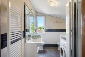 a bathroom with a sink and a toilet and a window at Emma e Adele House in Marlia +26 photos