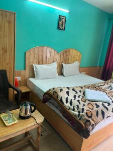 a bedroom with a bed with a wooden headboard at CL Villa Manali in Manāli